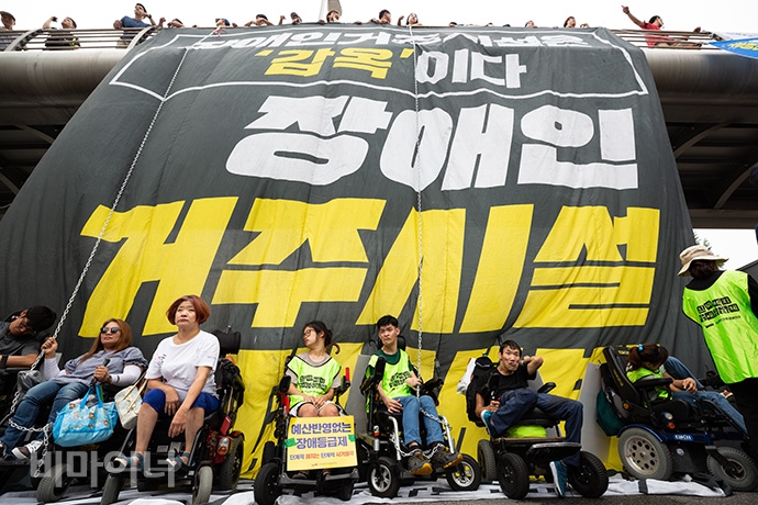 결의대회를 마친 전장연은 오후 4시 더불어민주당 당사가 있는 여의도 방향으로 행진을 했다. 가는 도중 충정로 사거리 육교에서 장애계 요구안이 담긴 대형 현수막을 내 거는 과정에서 경찰과 마찰을 빚기도 했다. 사진 박승원