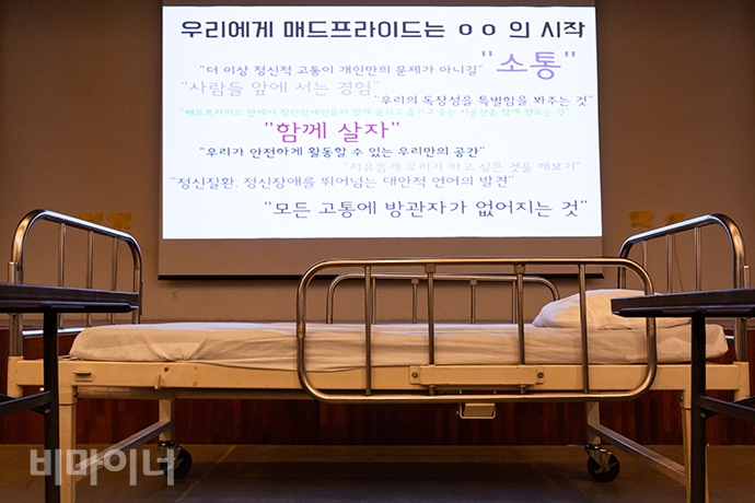 병원 침대 뒤로 매드프라이드를 준비하는 정신장애인 당사자들의 바람이 담긴 메시지가 스크린에 올라있다. 사진 박승원