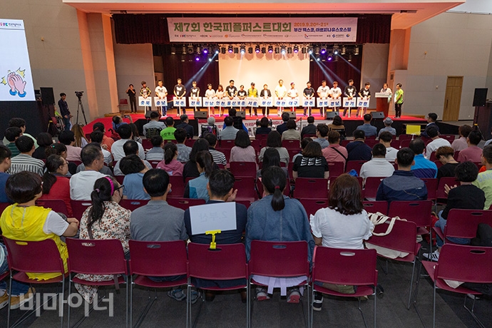 이날 대회에는 전국 1,049명의 발달장애인이 운집했다. 지역별 대표가 지역명이 쓰인 팻말을 들고 행진 후 무대에 선 모습. 사진 박승원 이날 대회에는 전국 1,049명의 발달장애인이 운집했다. 지역별 대표가 지역명이 쓰인 팻말을 들고 행진 후 무대에 선 모습. 사진 박승원