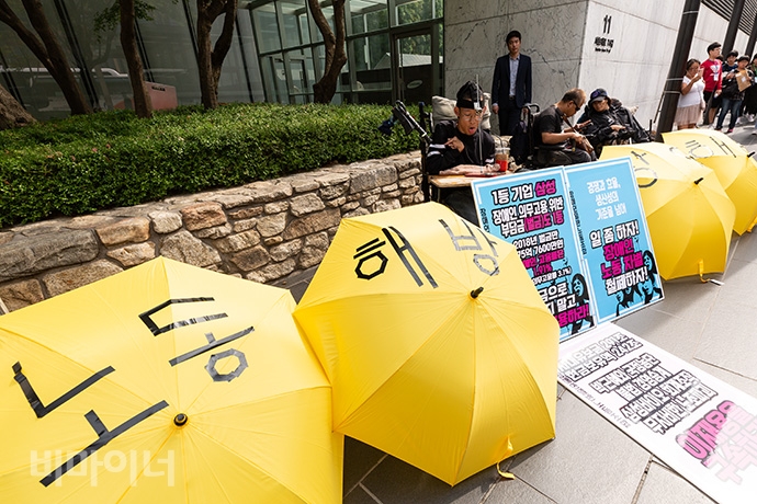 장애인일반노조 준비위가 삼성에 법이 정한 장애인 의무고용을 준수하라며 1일 오전 삼성전자 서초사옥 앞에서 1인 릴레이 시위에 들어갔다. 펼쳐진 노란 우산에는 ‘노동 해방, 장애 해방’이라고 적혀있다. 사진 박승원