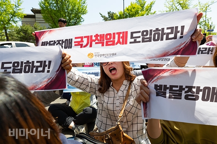 전국장애인부모연대가 지난 5월, 주간활동서비스 하루 8시간 보장을 요구하며 청와대 춘추관 앞에서 기습시위를 벌인 모습. 사진 박승원