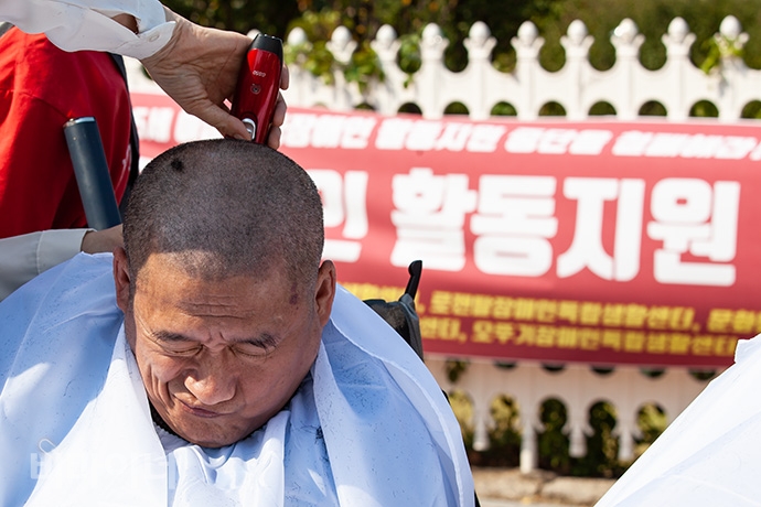 손거정 사랑샘장애인자립생활센터 활동가가 ‘만 65세 이상 장애인활동지원서비스 보장’을 촉구하며 삭발식을 하는 모습. 사진 박승원