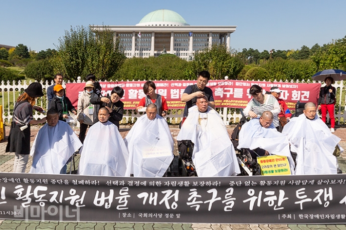 한국장애인자립생활센터총연맹이 8일 오전 국회 정문 앞에서 ‘만 65세 이상 장애인활동지원서비스를 보장하라’며 투쟁선포를 알리는 기자회견을 열고 삭발식을 벌였다. 사진 박승원 8일 국회 앞에는 6명의 중증장애인이 삭발식을 올렸다. 왼쪽부터 김홍우 밝은내일장애인자립생활센터 활동가, 이은철 밝은내일장애인자립생활센터 활동가, 이영호 청년장애인자립생활센터 소장, 박종우 한자총 부산경남지회 투쟁위원장, 손거정 사랑샘장애인자립생활센터 활동가, 장경수 한자총 투쟁위원장이다. 사진 박승원