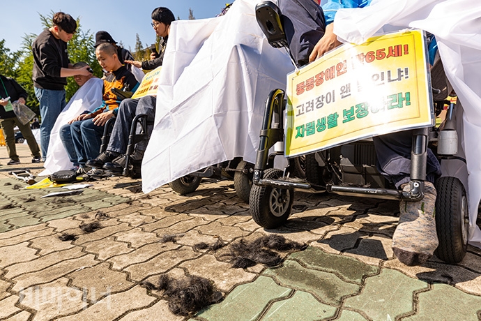 한국장애인자립생활센터총연맹이 8일 오전 국회 정문 앞에서 ‘만 65세 이상 장애인활동지원서비스를 보장하라’며 투쟁선포를 알리는 기자회견을 열고 삭발식을 벌였다. 사진 박승원 한국장애인자립생활센터총연맹이 8일 오전 국회 정문 앞에서 ‘만 65세 이상 장애인활동지원서비스를 보장하라’며 투쟁선포를 알리는 기자회견을 열고 삭발식을 벌였다. 사진 박승원