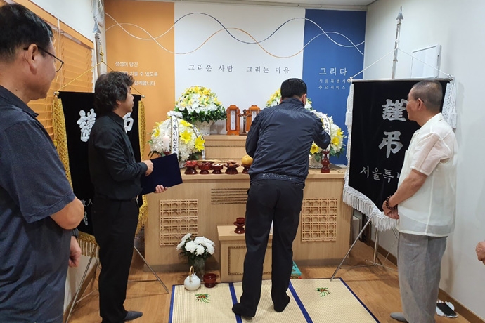 무연고 사망자가 된 친구의 장례식에서 술을 올리고 있는 친구