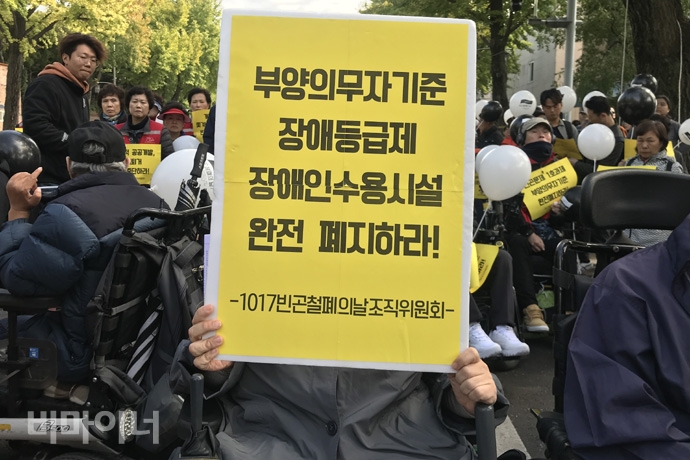 한 참가자가 ‘부양의무자기준, 장애등급제, 장애인수용시설, 완전 폐지하라!’라는 손팻말을 들고 있다. 사진 허현덕