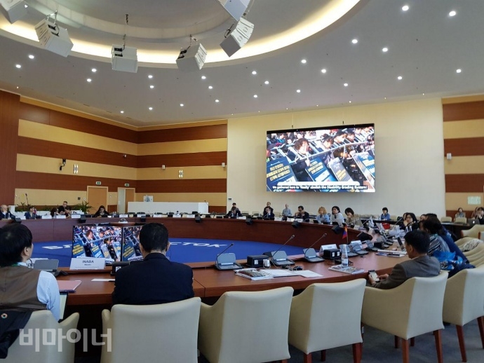 포럼에 참석한 각국 대표들이 사다리를 목에 걸고 투쟁하는 장애인단체의 영상을 시청하고 있다. 사진 이가연