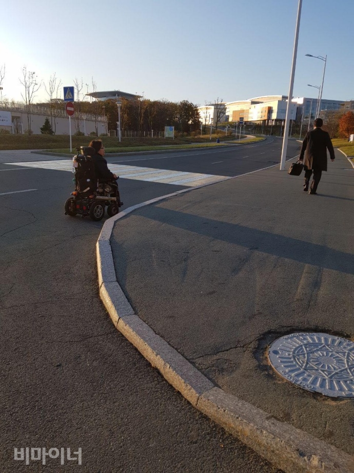 이형숙 노들장애인자립생활센터 대표가 인도의 경사로가 부족해 차도로 이동하고 있다. 사진 이가연