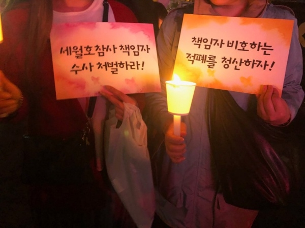 지난 4월 13일, 광화문에서 열린 세월호 참사 5주기 기억문화제에서 사람들이 “세월호 참사 책임자 수사 처벌하라”, “책임자 비호하는 적폐를 청산하자”라고 적힌 피켓을 들고 있다. 사진 워커스 박다솔 기자 