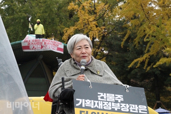 박명애 전국장애인차별철폐연대 상임공동대표가 닫는 발언을 하고 있다. 박 대표 뒤에는 형제복지원 사건의 진상규명을 위해 국회 앞 지붕위에서 고공 단식 농성 중인 최승우 씨가 보인다. 사진 이가연 박명애 전국장애인차별철폐연대 상임공동대표가 닫는 발언을 하고 있다. 박 대표 뒤에는 형제복지원 사건의 진상규명을 위해 국회 앞 지붕위에서 고공 단식 농성 중인 최승우 씨가 보인다. 사진 이가연