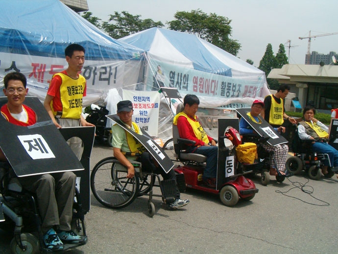 2006년 6월, 박기연 열사 장례 투쟁을 하며 인천시청 앞에서 천막농성을 하는 사람들. 사진 인천뇌병변장애인인권협회 2006년 6월, 박기연 열사 장례 투쟁을 하며 인천시청 앞에서 천막농성을 하는 사람들. 사진 인천뇌병변장애인인권협회