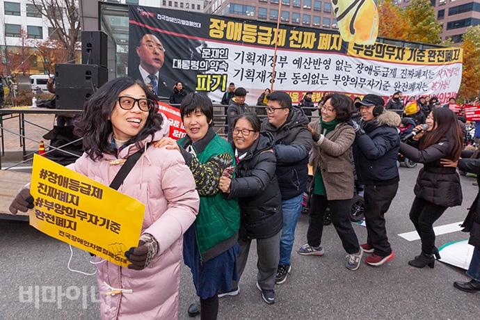 세계장애인의 날에 참여한 장애운동가 및 당사자들은 춤을 추고 기차놀이를 하며 투쟁으로 결의했다. 수리야 전장연 활동가가 기차놀이의 선두를 맡아 사람들을 이끌었다. 그 뒤에는 임정득 노동가수가 마이크를 들고 노래 부르며 뒤따르는 모습. 사진 박승원 세계장애인의 날에 참여한 장애운동가 및 당사자들은 춤을 추고 기차놀이를 하며 투쟁으로 결의했다. 수리야 전장연 활동가가 기차놀이의 선두를 맡아 사람들을 이끌었다. 그 뒤에는 임정득 노동가수가 마이크를 들고 노래 부르며 뒤따르는 모습. 사진 박승원