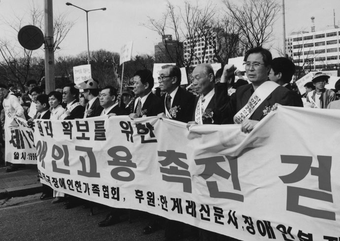 1996년 장애인고용촉진걷기대회에서 현수막을 들고 행진하는 사람들의 모습. 사진 정태수열사추모사업회