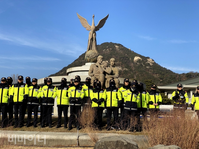 가족 동상에 검은 천을 둘러싸려는 활동가들을 저지한 경찰들이 동상을 에워싸 지키고 있다. 사진 이가연 
