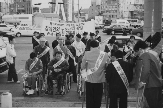 1996년 ‘제1회 장애인고용촉진 걷기대회’에 참석한 박흥수 열사. 앞에서 두 번째 줄 왼쪽에 빵모자를 쓰고 목발 짚은 사람이 박흥수 열사. 사진 장애해방열사 단 
