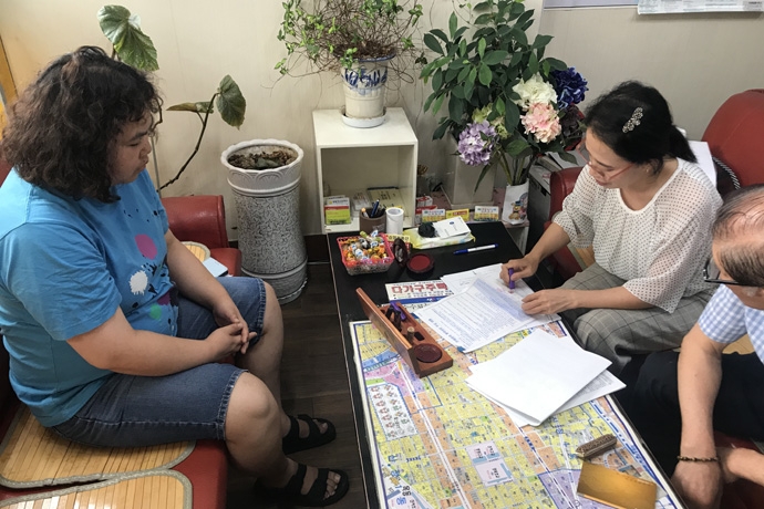 발달장애인과 주거매니저가 부동산에서 주택 계약을 하고 있는 모습. 사진 충현복지관