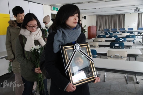 2011년 1월 4일, 우동민 열사가 마지막으로 투쟁한 인권위 배움터에서 국화꽃과 고인의 영정을 들고서 추모하는 활동가들. 