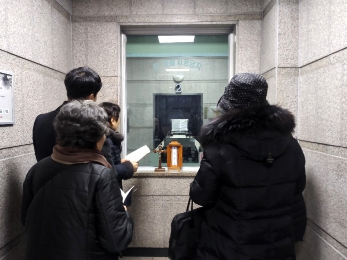 24일, 무연고 사망자의 장례식에 참석한 신부와 신자들이 화장장 앞에서 기도를 하고 있다. 사진제공 나눔과나눔