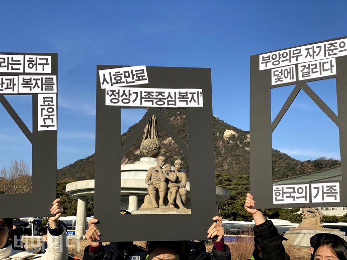 기초법바로세우기공동행동 등은 지난 19일, 청와대 사랑채 분수 앞에서 부양의무자 기준 완전 폐지를 위한 청와대 앞 농성을 마무리하는 기자회견을 열었다. 이날 기자회견에 참석한 활동가들이 ‘시효만료 정상가족 중심복지’라고 적힌 액자 피켓을 들고, 이른바 ‘정상 가족’을 뜻하는 가족 동상의 모습을 액자에 담으려 하고 있다. 사진 이가연 기초법바로세우기공동행동 등은 지난 19일, 청와대 사랑채 분수 앞에서 부양의무자 기준 완전 폐지를 위한 청와대 앞 농성을 마무리하는 기자회견을 열었다. 이날 기자회견에 참석한 활동가들이 ‘시효만료 정상가족 중심복지’라고 적힌 액자 피켓을 들고, 이른바 ‘정상 가족’을 뜻하는 가족 동상의 모습을 액자에 담으려 하고 있다. 사진 이가연