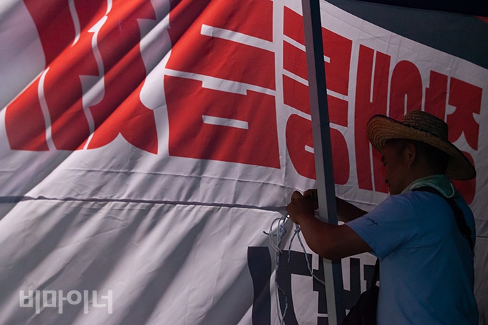 7월 1일 장애등급제 ‘진짜’ 폐지 투쟁 선포를 외친 1,500여 명 장애인 활동가들은 사회보장위원회 앞으로 찾아가 1박 노숙농성을 벌였다. 박문규 노들 활동가가 노숙농성을 위한 천막을 설치하는 모습. 사진 박승원