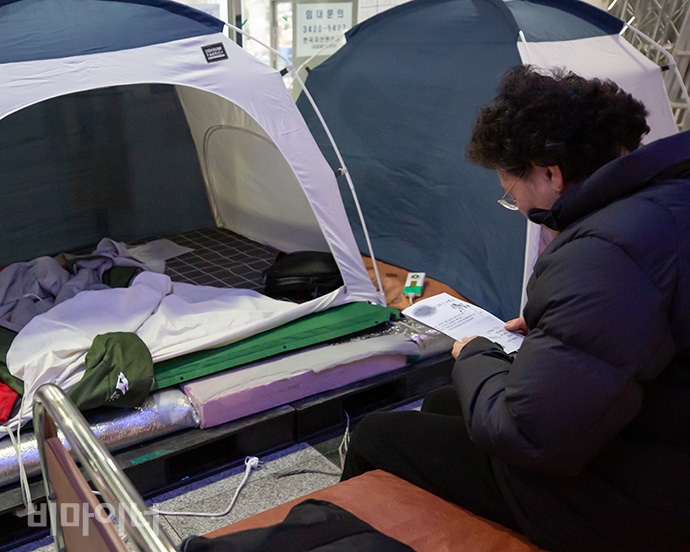 고 우동민 활동가 어머니 권순자 씨가 인권위 1층 고 설요한 분향소 뒤쪽에 마련된 농성 텐트 앞에서 우동민 활동가의 일기를 읽고 있다. 사진 박승원 고 우동민 활동가 어머니 권순자 씨가 인권위 1층 고 설요한 분향소 뒤쪽에 마련된 농성 텐트 앞에서 우동민 활동가의 일기를 읽고 있다. 사진 박승원