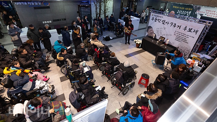2일 오후 4시 30분 인권위 1층 로비에서 100여 명의 장애인 활동가가 고 우동민 활동가 9주기 추모제를 지냈다. 박준 노동가수가 노래하고 있는 모습. 사진 박승원