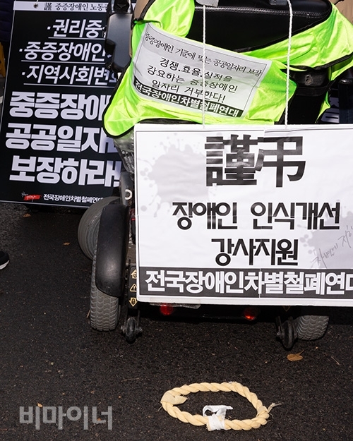 지난해 12월, 고 설요한 동료지원가 장례식에 참석한 한 장애인이 “근조 장애인 인식개선 강사지원”이라고 적힌 피켓을 들고 있다. 사진 박승원