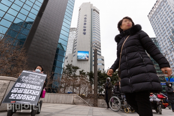 한 장애인 활동가가 서울고용노동청이 보이는 삼일대로13길 쪽에서 설요한 영정사진을 매고 중증장애인 공공일자리 문제를 시민에게 알리는 1인 시위를 했다. 사진 박승원