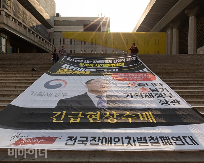 2019년 5월, 전국장애인차별철폐연대가 장애등급제 ‘진짜’ 폐지를 위한 예산 확대를 요구하며 홍남기 기획재정부 장관을 ‘긴급 현상수배’하는 대형 현수막을 세종문화회관 중앙 계단에 내걸었다. 사진 박승원