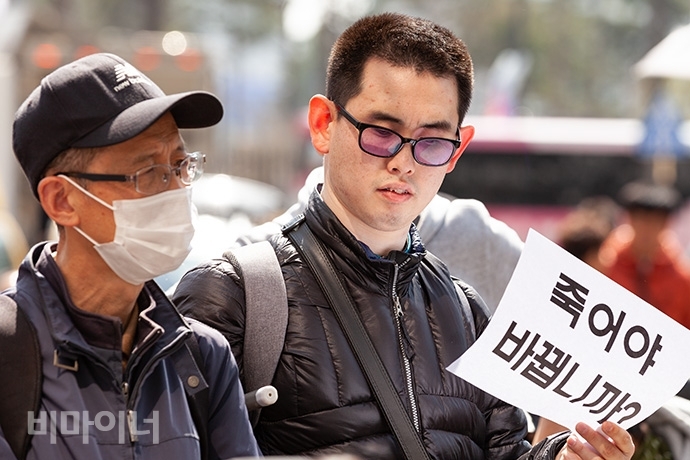 장애인차별금지추진연대는 지난해 3월 26일 세종시 보건복지부청사 앞에서 기자회견을 열고, 메르스로 촉발된 장애인 재난 감염 관련 소송에 무책임한 태도로 일관하는 복지부를 규탄했다. 이날 기자회견 참가자가 ‘죽어야 바뀝니까?’라는 손팻말을 들고 있다. 사진 박승원