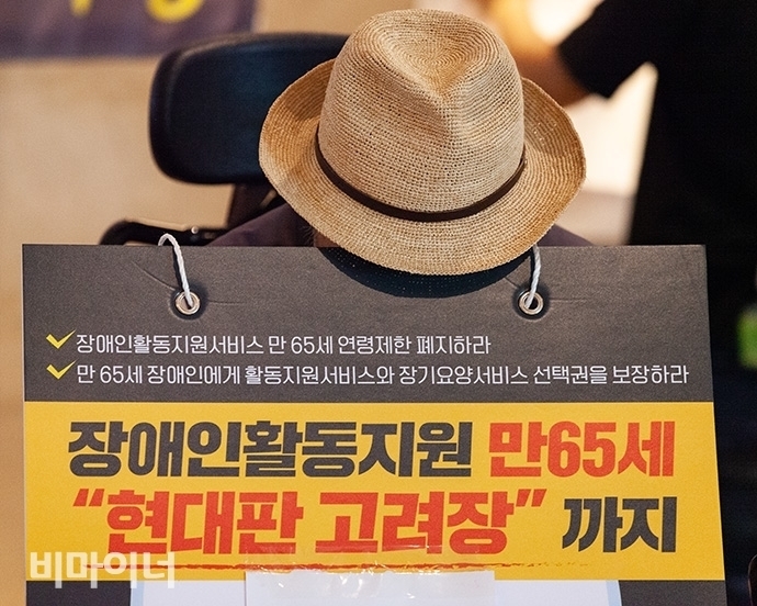 ‘장애인활동지원 만 65세, 현대판 고려장’이라는 문구가 쓰인 팻말. 사진 박승원  