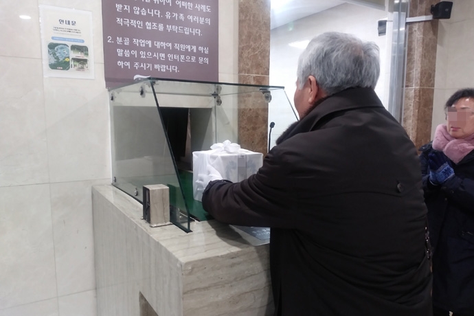 한 달 간격으로 조카와 누나의 무연고 장례를 치른 유가족이 유골함을 받고 있다. 사진 나눔과 나눔 한 달 간격으로 조카와 누나의 무연고 장례를 치른 유가족이 유골함을 받고 있다. 사진 나눔과 나눔