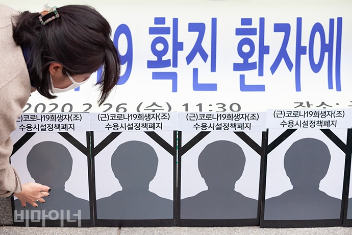 한 장애인 활동가가 코로나19 희생자를 추모하기 위해 마련한 영상사진 11개를 가지런히 세우고 있다. 사진 박승원