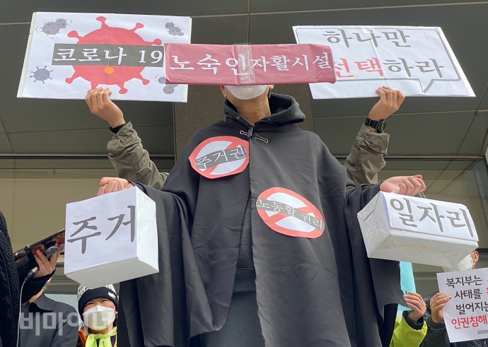9일, 홈리스행동 등은 국가인권위원회가 소재한 서울 중구 나라키움 저동빌딩 앞에서 M시설에 대한 진정과 긴급구제를 요청하는 기자회견을 열었다. 기자회견이 끝나고 김호태 동자동사랑방 대표가 코로나19로 인해 노숙인자활시설 입주민에게 주거와 일자리 중 하나만 선택하라는 현 상황을 표현하는 퍼포먼스를 진행하고 있다. 사진 이가연 