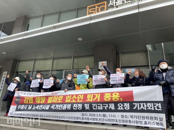 9일, 국가인권위원회가 있는 서울 중구 나라키움 저동빌딩 앞에서 기자회견에 참여한 활동가들이 ‘감염 예방 빌미로 입소인 퇴거 종용, 수원시 M 노숙인시설 국가인권위 진정 및 긴급구제 요청 기자회견’이라고 적힌 피켓을 들고 구호를 외치고 있다. 사진 이가연