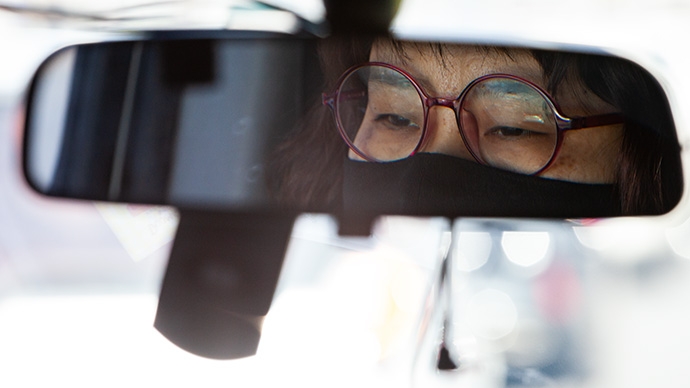 황보경 질라라비야학 사무국장이 배달할 식품을 특장차에 싣고 운전대를 잡았다. 백미러에 황 사무국장이 비친 모습. 사진 박승원