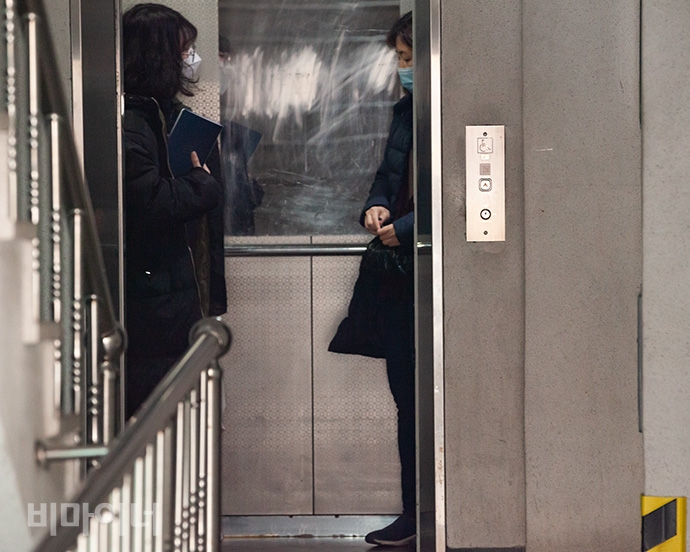 다릿돌센터 이효림·노진영 활동가가 다시 찾아간 어느 자립생활주택 엘리베이터에 오른 모습. 노 활동가 손에는 양말이 담긴 검은 봉지가 들려있고, 이 활동가는 그런 노 활동가를 바라보고 있다. 사진 박승원