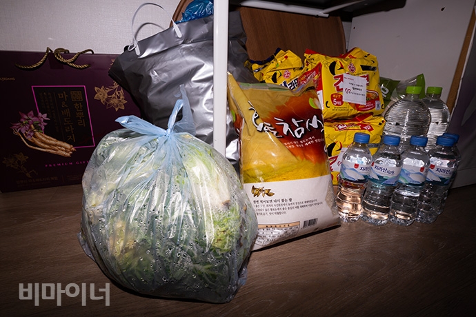 정부에서 지원받은 식품인 배추와 생쌀, 라면이 가지런히 놓여있다. 조리할 수 없는 김성민 씨는 자가격리하는 동안 이 세 가지 식품을 하나도 먹을 수 없었다. 투명한 봉투 안에 담긴 배추가 썩어 문드러졌다. 사진 박승원