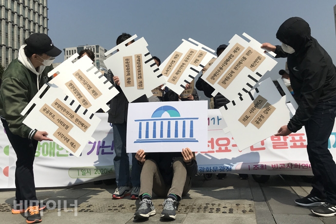 장애인과 가난한 사람들의 요구가 담긴 주삿바늘을 국회의사당에 주입하는 퍼포먼스를 펼치는 사람들. 사진 허현덕 