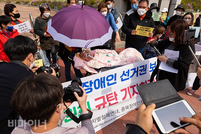 투표를 마친 뒤 장야초등학교 정문 앞에서 선관위를 규탄하는 기자회견이 열렸다. 수찬 씨를 중심으로 기자들이 사진을 찍고 있다. 사진 박승원