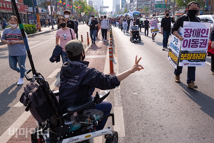문애린 서울장애인차별철폐연대 공동대표가 활동가들에게 2M 간격으로 떨어져 행진하라고 외치고 있다. 사진 박승원