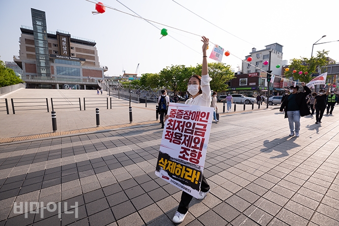 장혜영 정의당 국회의원 당선자가 ‘중증장애인 최저임금 적용제외 조항 삭제하라’ 손팻말을 못에 걸고 함께 행진하고 있다. 사진 박승원