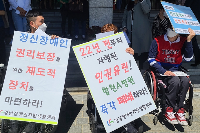 기자회견에 참여한 장애인 활동가들이 ‘정신장애인 권리보장을 위한 제도적 장치를 마련하라’ ‘22년 전부터 자행된 인권유린! 합천 A 병원 즉각 폐쇄하라’라고 적힌 손팻말을 들고 있다. 사진 민경선 진해장애인인권센터 활동가 제공