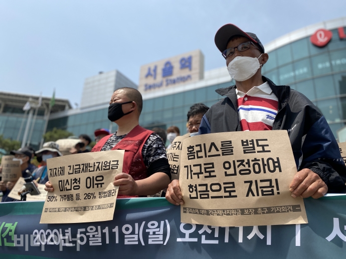 홈리스행동 등은 11일, 서울역 광장 앞에서 홈리스에 대한 긴급재난지원금 보장을 촉구하는 긴급 기자회견을 열었다. 서울역 광장 앞에서 기자회견에 참여한 활동가들이 ‘홈리스를 별도 가구로 인정하여 현금으로 지급!’, ‘지자체 긴급재난지원금 미신청 이유 50% 거주불명 등, 26% 방법 몰라’라고 적힌 피켓을 들고 있다. 사진 이가연