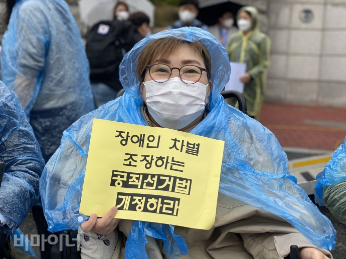 박김영희 장애인차별금지추진연대 상임대표가 ‘장애인 차별 조장하는 공직선거법 개정하라’라고 적힌 피켓을 들고 있다. 사진 이가연