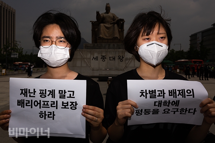 노유경 한신대학교 총학생회장(왼쪽부터)과 이지민 한신대학교 사회복지학과 정책학회장이’ 차별과 배제의 대학에 평등을 요구한다’와 ’재난 핑계 말고 배리어프리 보장하라’라고 적힌 손팻말을 들고 있다. 사진 박승원