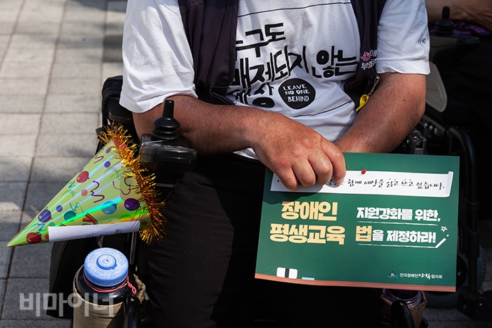 김명학 노들장애인야간학교 학생이 ‘장애인 평생교육 지원강화를 위한, 장애인 평생교육법 제정하라’라고 적힌 손팻말을 들고 있다. 사진 박승원