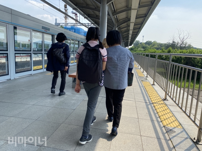 정아 씨와 정아 씨의 활동지원사가 손을 잡고 지하철 승강장을 걷고 있다. 사진 이가연