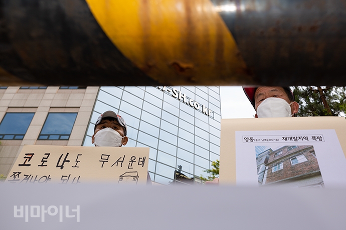 양동·동자동 주민들이 서울SH본사 주차장 입구에 세운 바리케이드 뒤에서 “코로나도 무서운데 쫓겨나야 하나”, “양동(중구 남대문로5가동) 재개발지역 쪽방”이라고 적힌 손팻말을 들고 기자회견에 참여했다. 사진 박승원