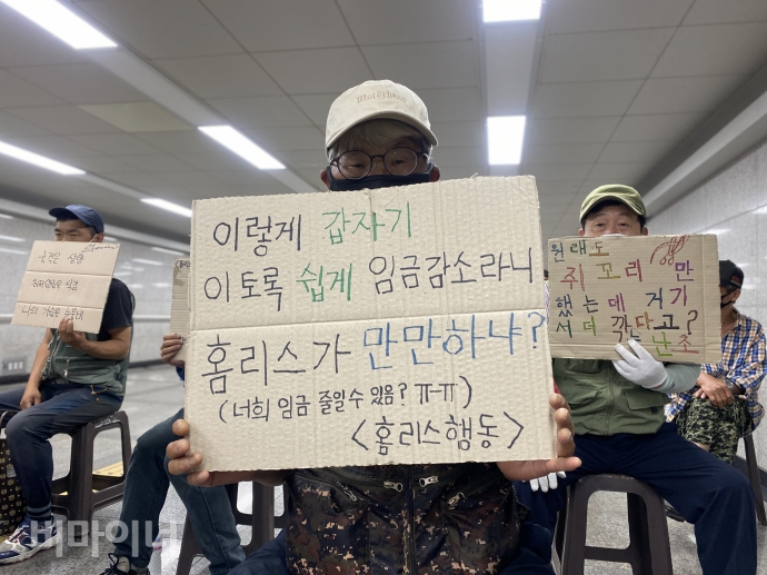 홈리스행동 등이 29일 오전 10시 30분, 서울역 연세빌딩 지하도에서 기자회견을 열어 서울시의 ‘홈리스 쪼개기 고용’ 개편안의 전면 철회와 공공일자리 전면 확대를 촉구했다. 한 홈리스행동 활동가가 ‘이렇게 갑자기 이토록 쉽게 임금감소라니. 홈리스가 만만하냐?(너희 임금 줄일 수 있음? ㅠㅠ)’라고 적힌 피켓을 들고 있다. 사진 이가연